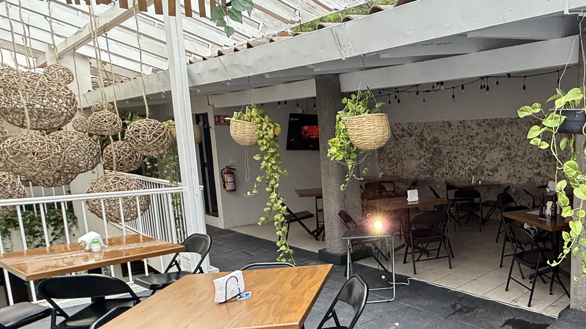 La terraza de MACANA a lo ancho, con el piso de piedra y la barra al fondo